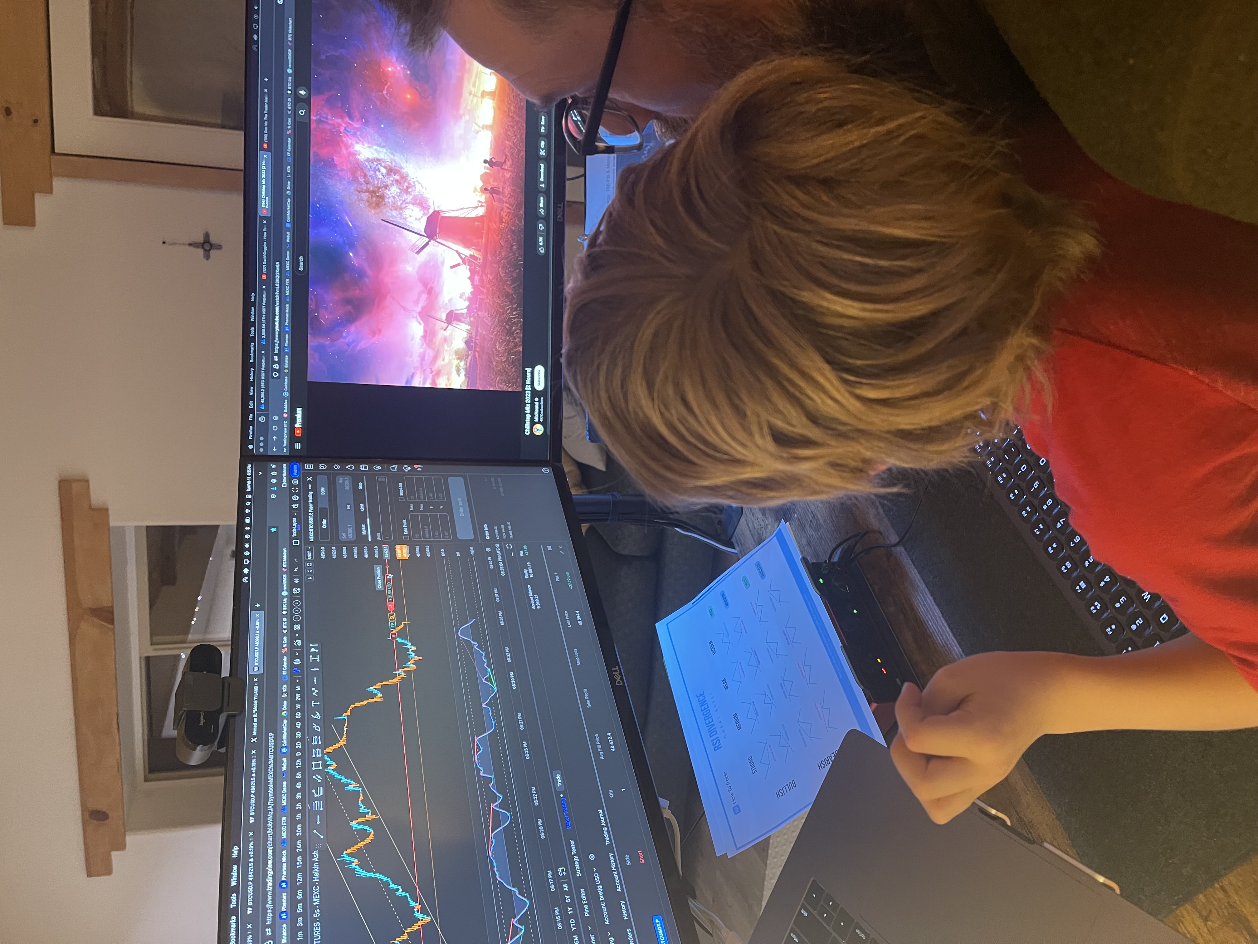 Bret James and his son studying financial-market charts at a trading desk